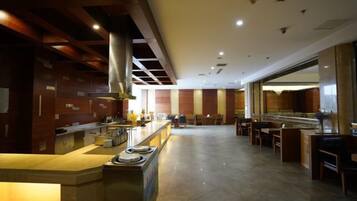 A spacious hotel lobby with a central bar area, seating arrangements, and a modern design.