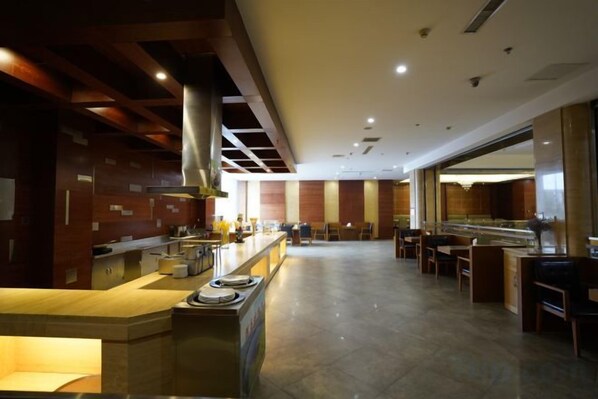 A spacious hotel lobby with a central bar area, seating arrangements, and a modern design.