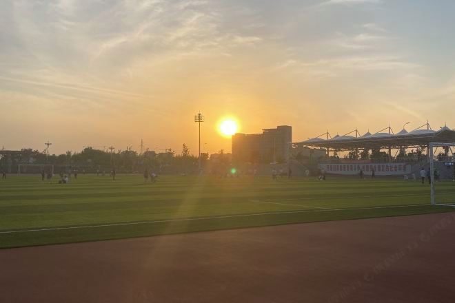 Un estadio con vista despejada al campo y zonas de asiento al atardecer.