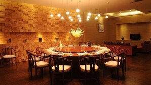 A dining area with a round table, chairs, and a brick wall. - Hui Nan Hotel (Huinan)