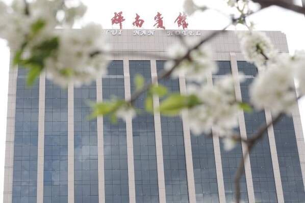 A modern hotel building with a sign reading "Fujian Hotel" in red characters.