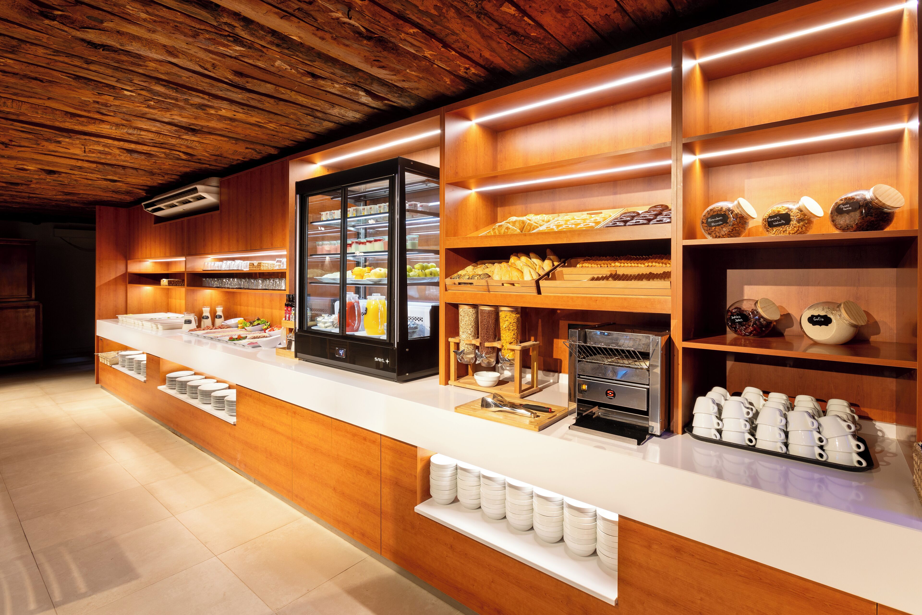 A buffet area with a wooden counter, glass display cases, and various food items.