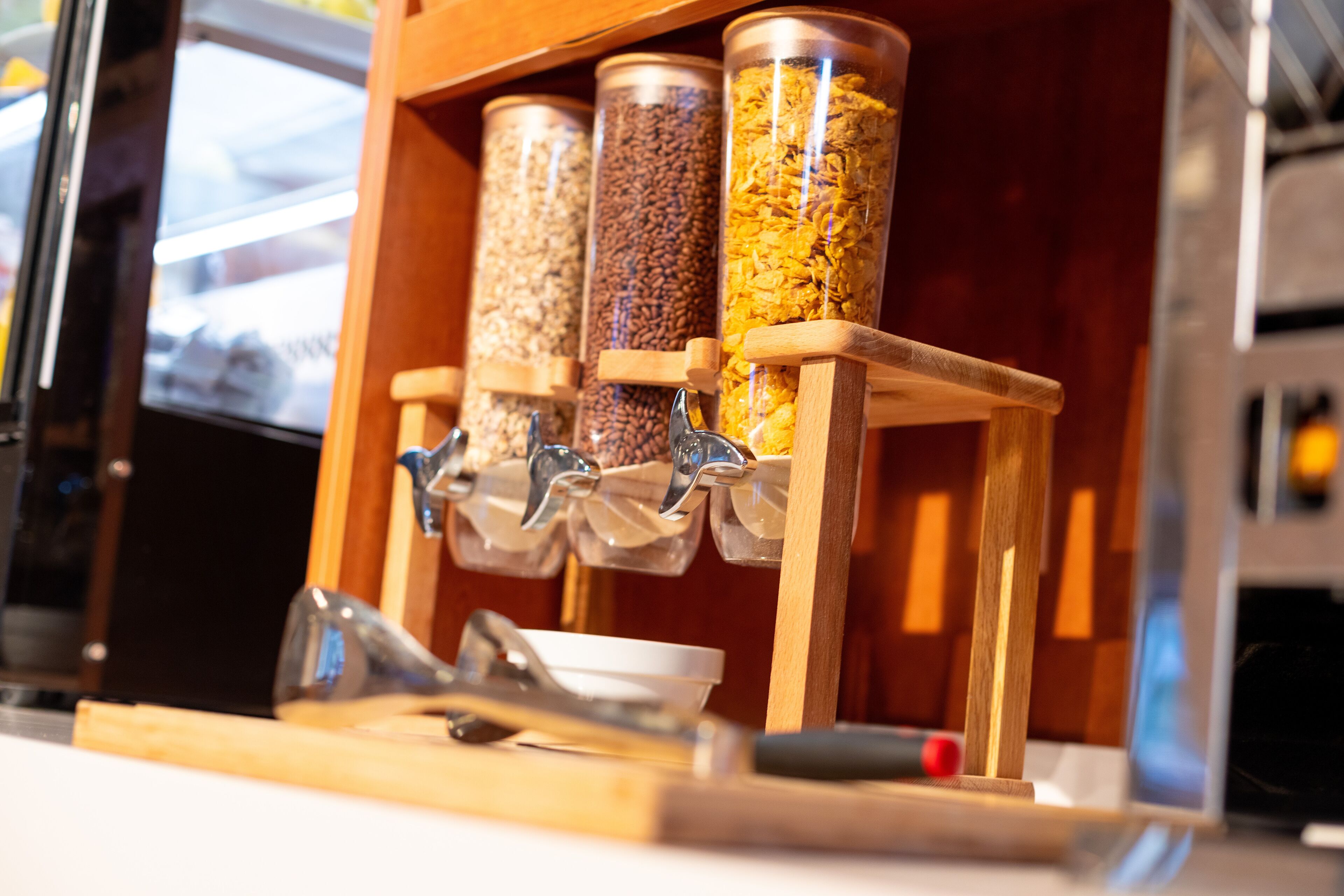 A wooden dispenser with multiple containers holding different grains.