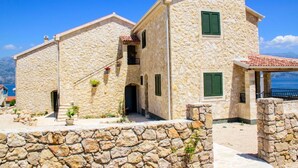 A stone building with a balcony and a view of the sea. - Wild Wind Residence (Razanac)
