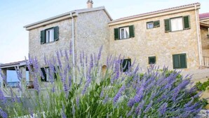A stone building with green shutters and a garden with lavender. - Wild Wind Residence (Razanac)