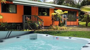 Een bubbelbad voor een huis met een rode gevel en een klein terras.