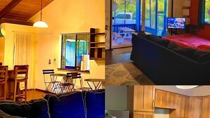 Een gezellige woonkamer met een bank, eettafel en stoelen. Er is een keuken met houten kasten en apparatuur.
