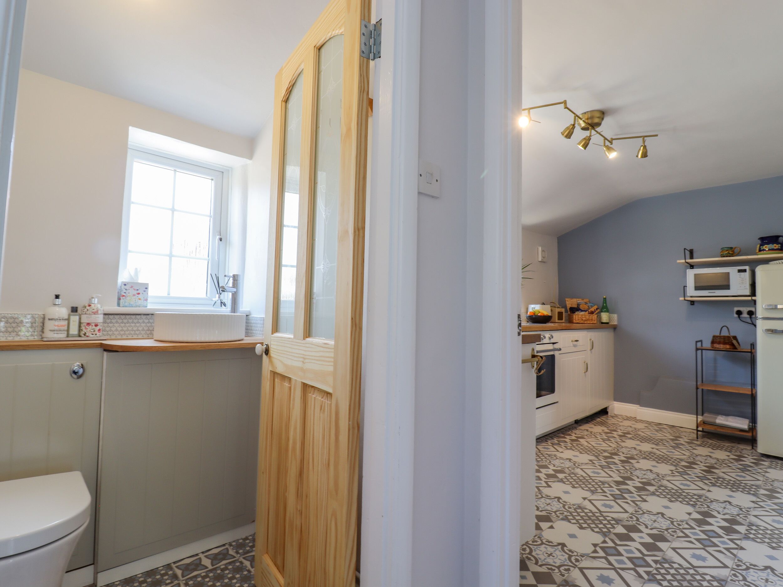 A compact kitchen with a window, a microwave, and a sink.