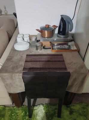 A small kitchenette with a stove, kettle, and various kitchen items on a table. - Family-friendly, 72sm Bedroom in Nikaia close to Metro St & Peiraeus Port (Nikea)