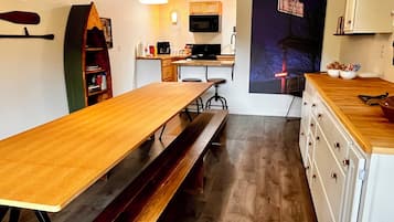 A modern kitchen with a wooden countertop, a built-in oven, and a microwave.