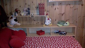 A child's bedroom with a bed, shelves with stuffed animals, and a toy car. - Attic with lake view (Campodolcino)