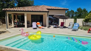 A pool area with a tiled roof structure, lounge chairs, and a swimming pool. - Recent villa with air conditioning and private pool on the heights of Barjac (Barjac)