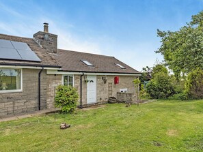 A stone house with a solar panel, a white door, and a mailbox. - Greystones Nawab Annex C (Flagg, Buxton)
