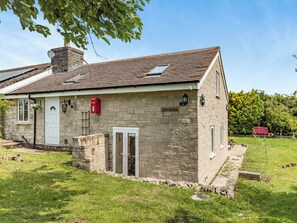 A stone house with a white door, a small porch, and a garden. - Greystones Nawab Annex C (Flagg, Buxton)
