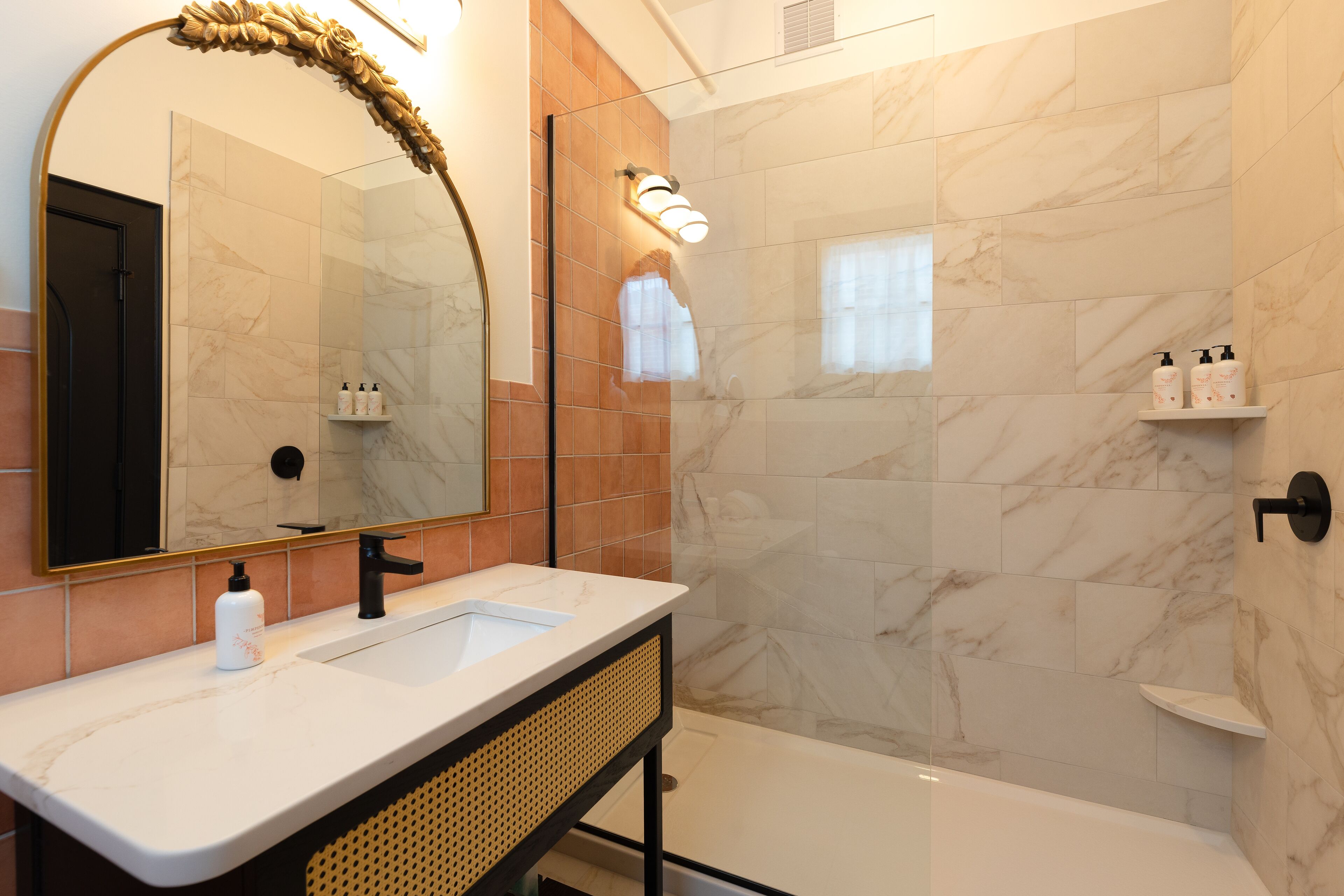 Un baño moderno con un espejo grande, dos lavamanos, una bañera y una ducha.