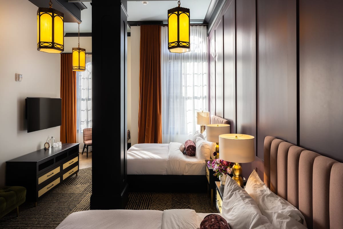 Une chambre d’hôtel avec un lit, une télévision, un bureau et une chaise.