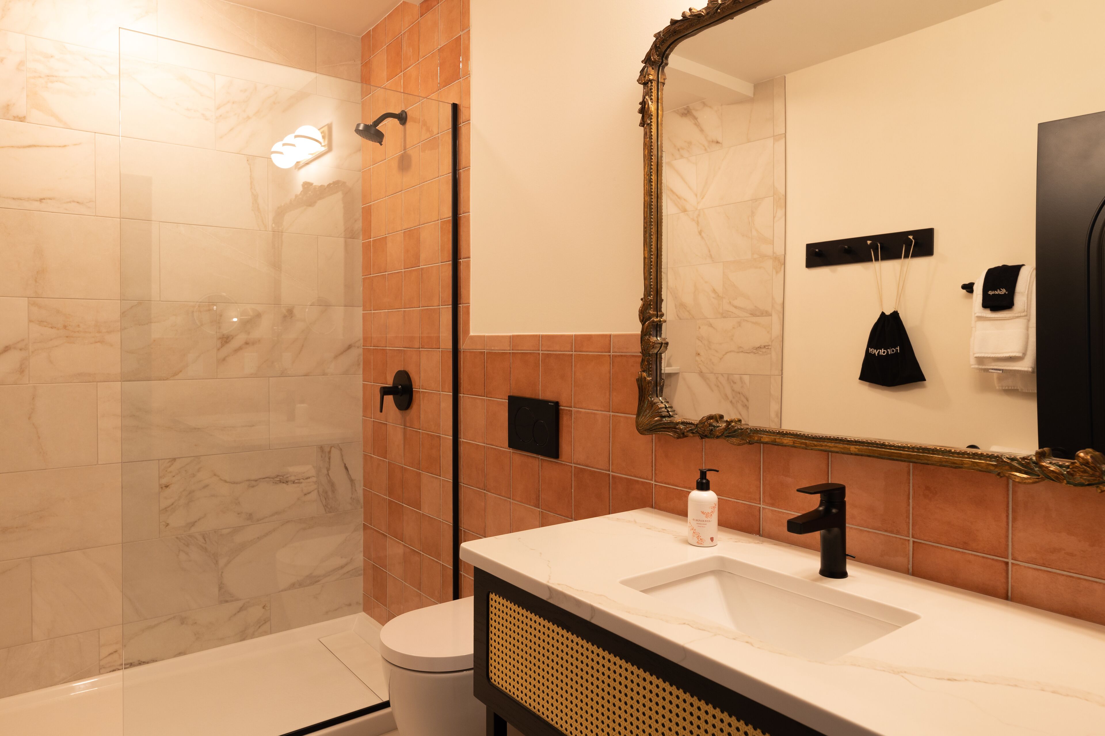 A bathroom with a white sink, a large mirror, and a shower area.