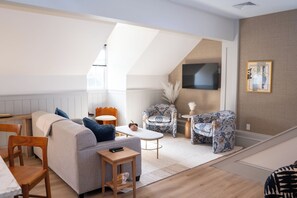 Loftsleilighet – superior | Oppholdsområde | En 50-tommers smart-TV med digitale kanaler samt Netflix og bøker