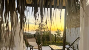 A terrace with a view of the sunset, wooden furniture, and a white canopy. - Rustic Hill Private Pool Rooms (Kalamata)