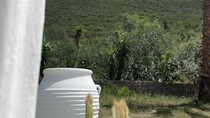 A white water feature in a garden with a hill in the background. - Rustic Hill Private Pool Rooms (Kalamata)