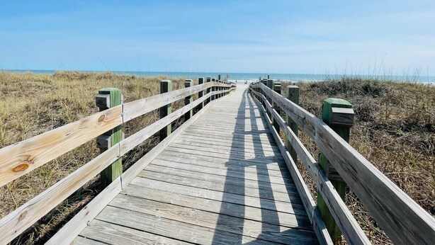 A wooden boardwalk leading to the beach. - Spacious 7 BD walk to the beach + pool (North Myrtle Beach)