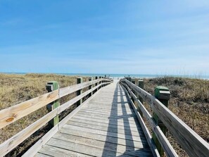 Ein hölzerner Steg, der zum Strand führt.