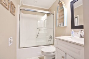 Bathtub, hair dryer, towels, toilet paper