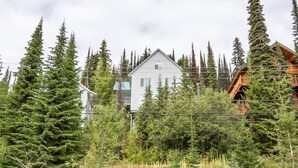 A cabin surrounded by dense forest, with a clear view of the surrounding trees and a wooden deck. - 3 Bed/2 Bath Home w/amazing views, BBQ, laundry, close to village & trails (Star Mountain)