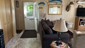 Ein gemütliches Wohnzimmer mit einer Couch, einem Couchtisch, einem Fernseher und einem Kamin.
