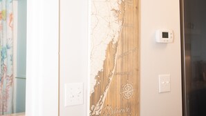 Une cuisine avec un élément décoratif mural en bois, un réfrigérateur en acier inoxydable et un thermostat.