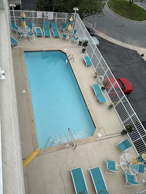 Relax by the pool surrounded by lush greenery and comfortable lounge seating.