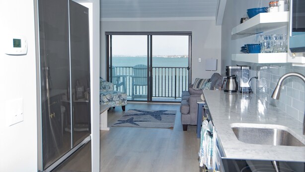 Une cuisine moderne avec une grande fenêtre, un coin repas avec un canapé et une vue sur la mer.