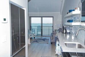 Une cuisine moderne avec une grande fenêtre, un coin repas avec un canapé et une vue sur la mer.