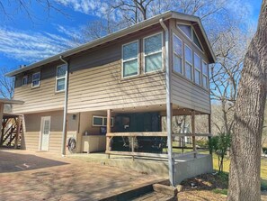 A two-story house with a covered porch, a garage, and a visible outdoor seating area.