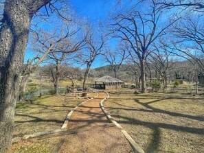A park with a wooden pathway leading to a gazebo.