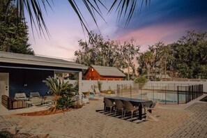 A poolside area with lounge chairs, a barbecue grill, and a covered seating area. - A Port in the Storm - Shangri La, Poolside Estate in Isle of Armstrong (Thunderbolt)