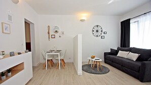 Un salon moderne comprenant un coin repas, un canapé et une horloge murale.