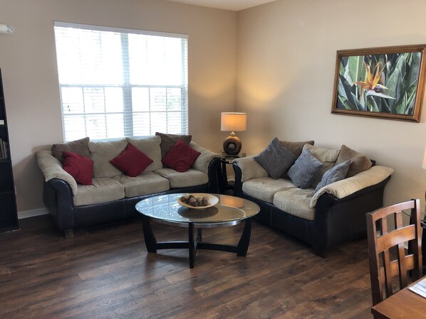 A living room with two sofas, a coffee table, and a lamp.