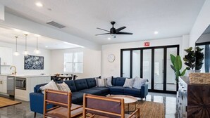 Una sala de estar moderna con un sofá modular, un comedor y una cocina.