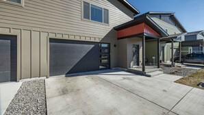 Une maison moderne à deux étages, dotée d’un garage, d’un porche abrité et d’une allée bien entretenue.