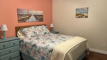 Un dormitorio con una cama, dos mesitas de noche y dos lámparas de pared.