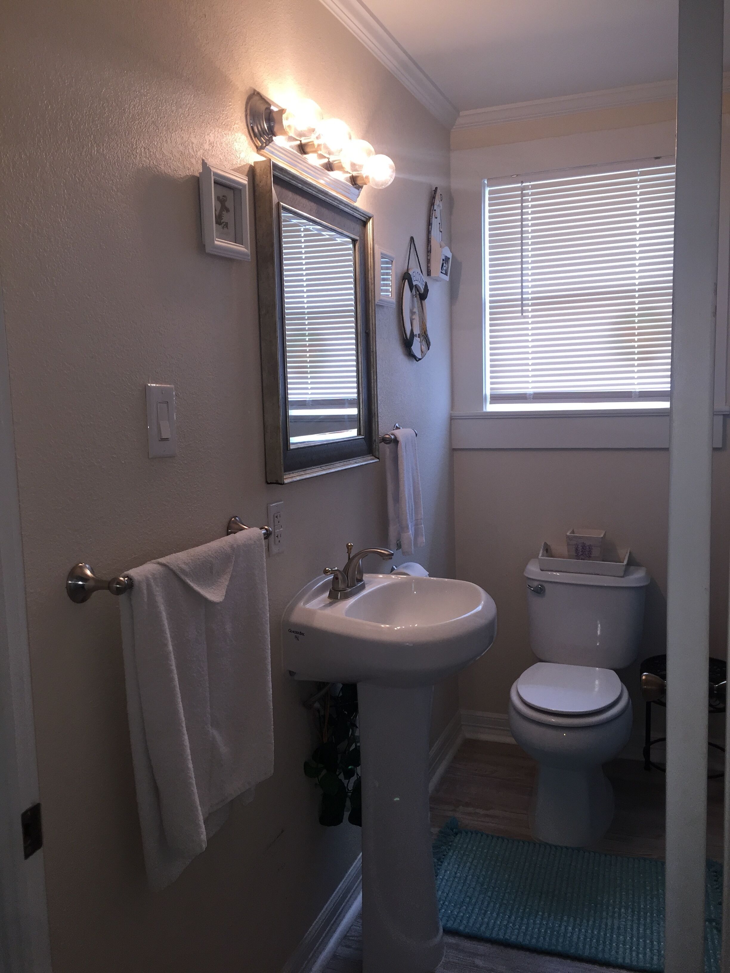 A bathroom with a sink, mirror, and toilet.