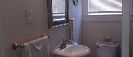 A bathroom with a sink, mirror, and toilet.