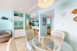 Relax in this open-plan living space with a kitchen area, featuring a sofa, dining table, and central island.