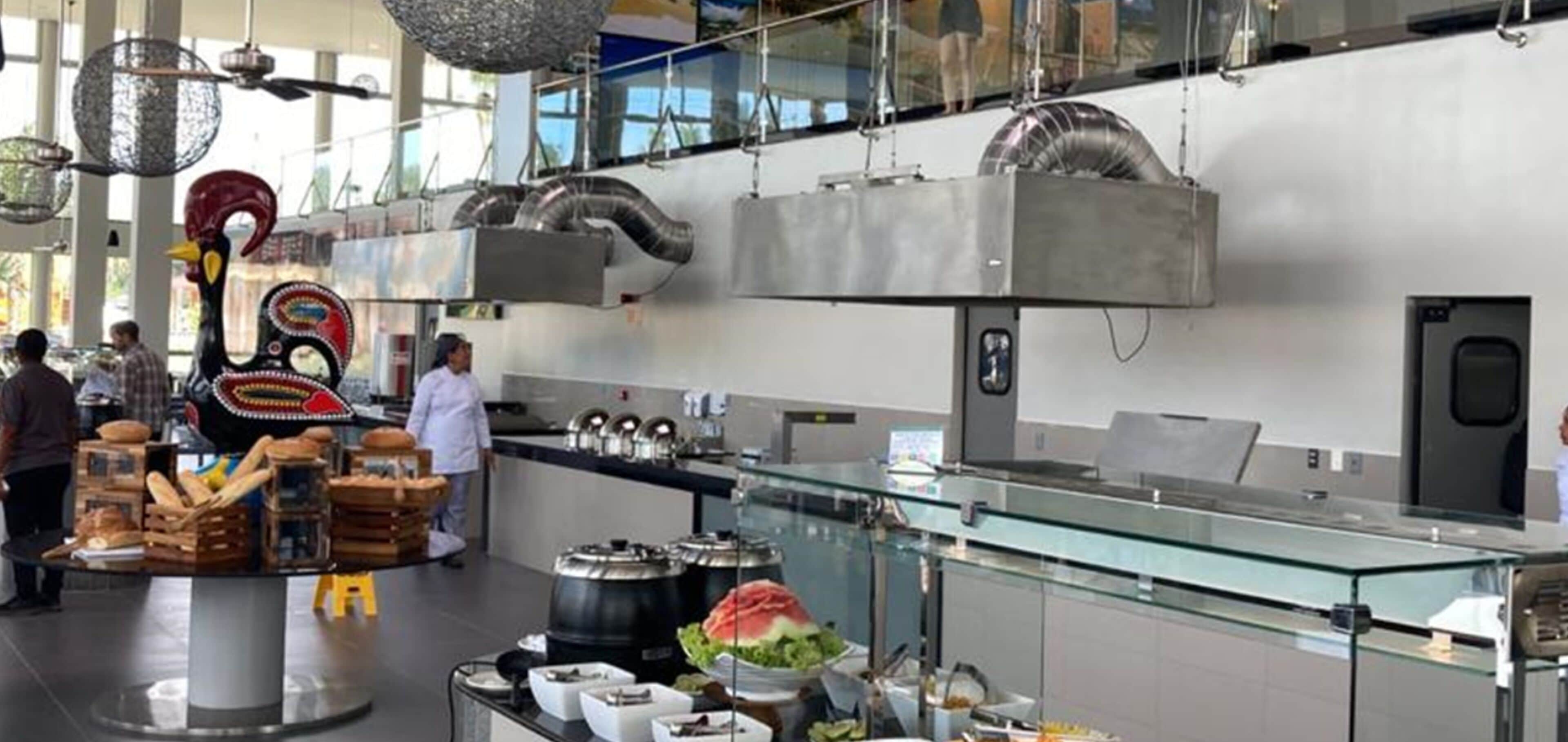 Een moderne keuken met roestvrijstalen apparatuur, een glazen vitrine en een decoratieve sculptuur van een haan.