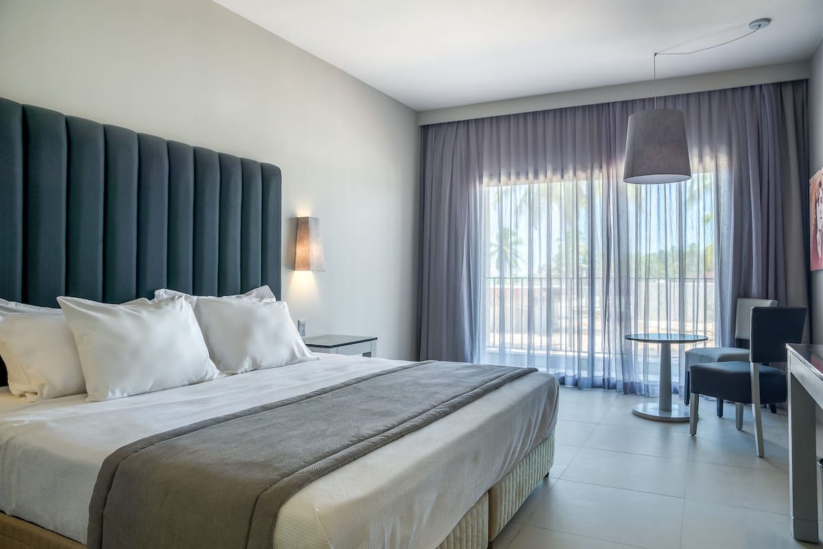 Una habitación de hotel moderna con una cama grande, un escritorio y una silla.