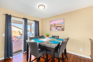 A dining area with a table set for four, a potted plant, and a painting of a desert landscape. - Paradise in Rita Ranch - HEATED POOL  (Tucson)