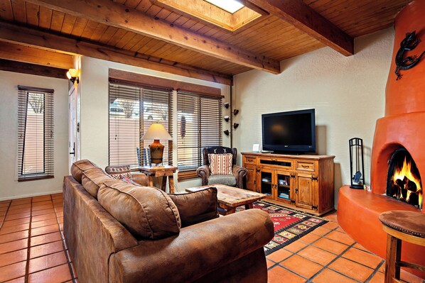 A living room with a leather sofa, wooden coffee table, and a fireplace.