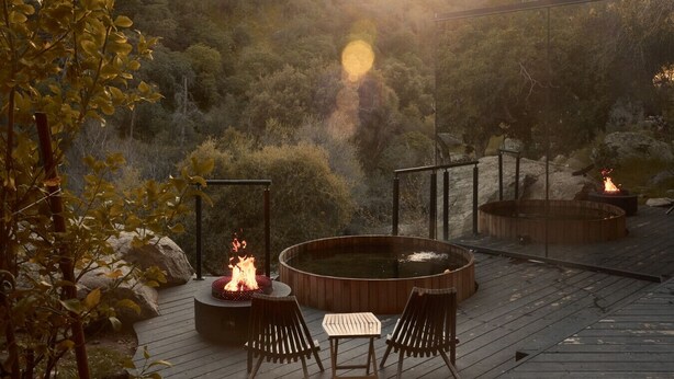 A deck with a hot tub, two chairs, and a fire pit. - Paradise Ranch Inn Stellar House Hot-Tub,Sauna . (three rivers)