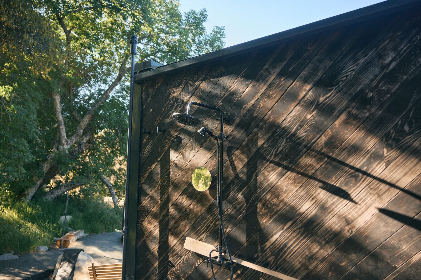 A wooden structure with a metal roof, a metal ladder, and a circular object on the wall.